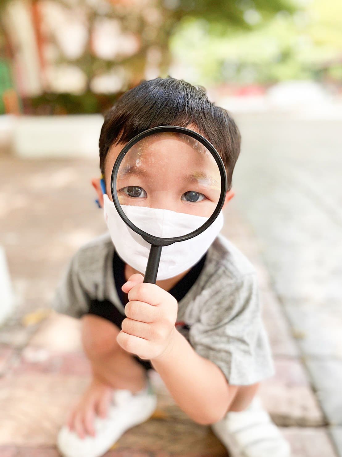 Kindergarten boy with a magnifying glass