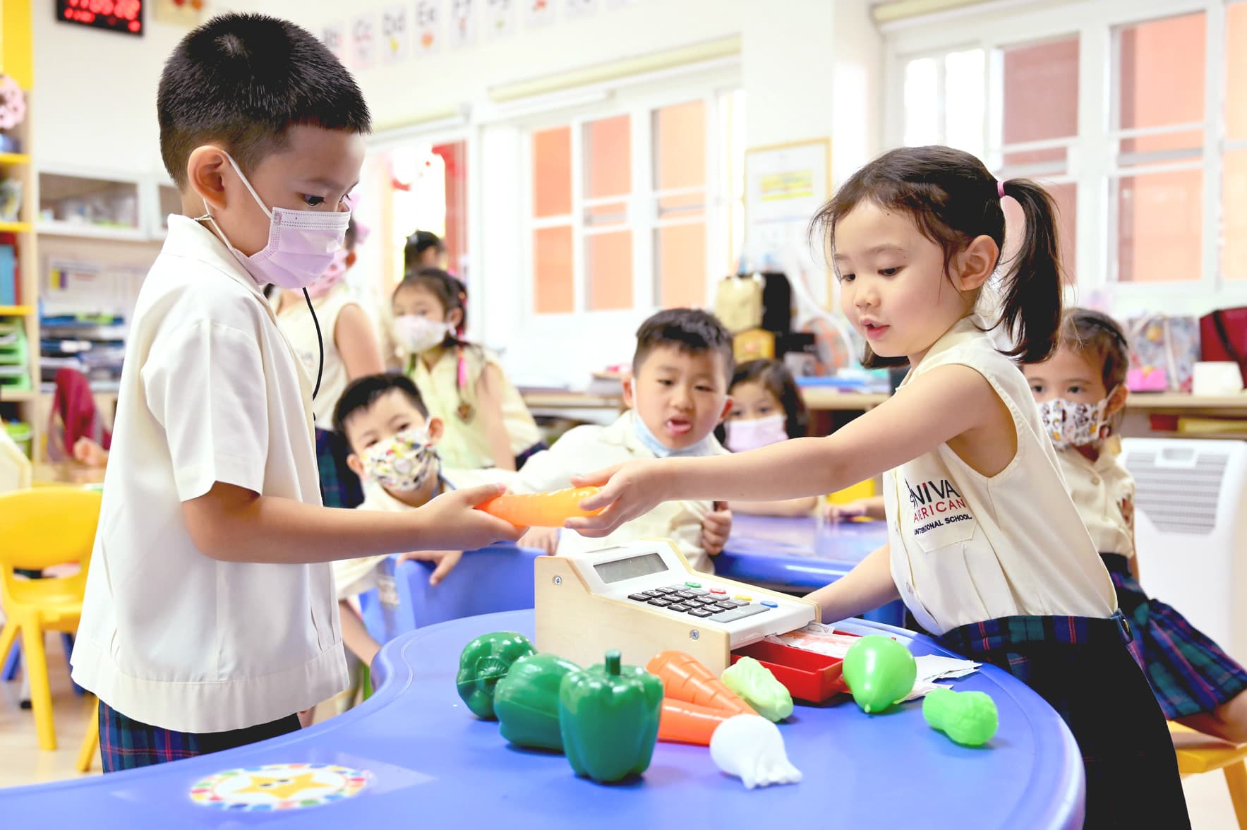 NIVA kindergarten students engaging in theme-based learning, role playing a vegetable market setting.