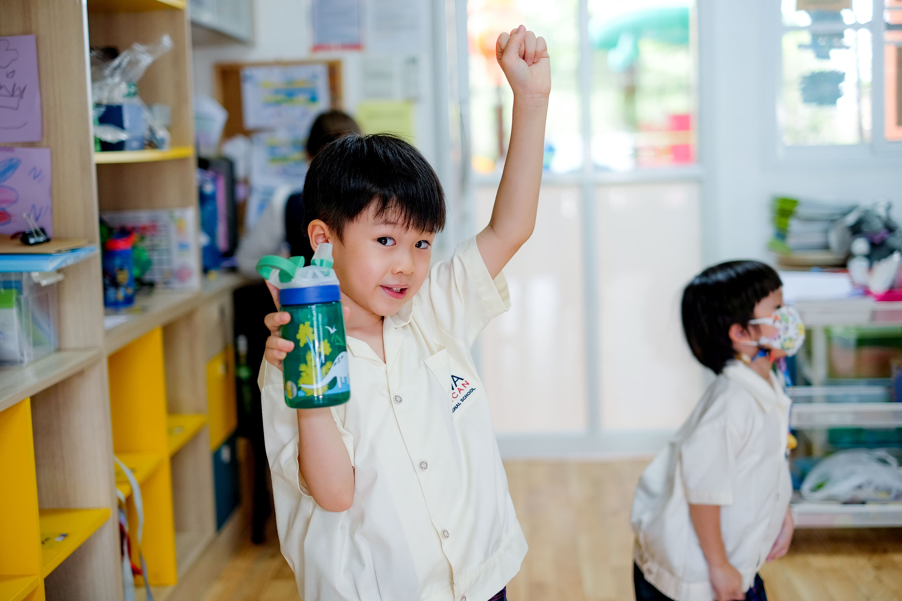 A NIVA American International School kindergarten student holding his water bottle