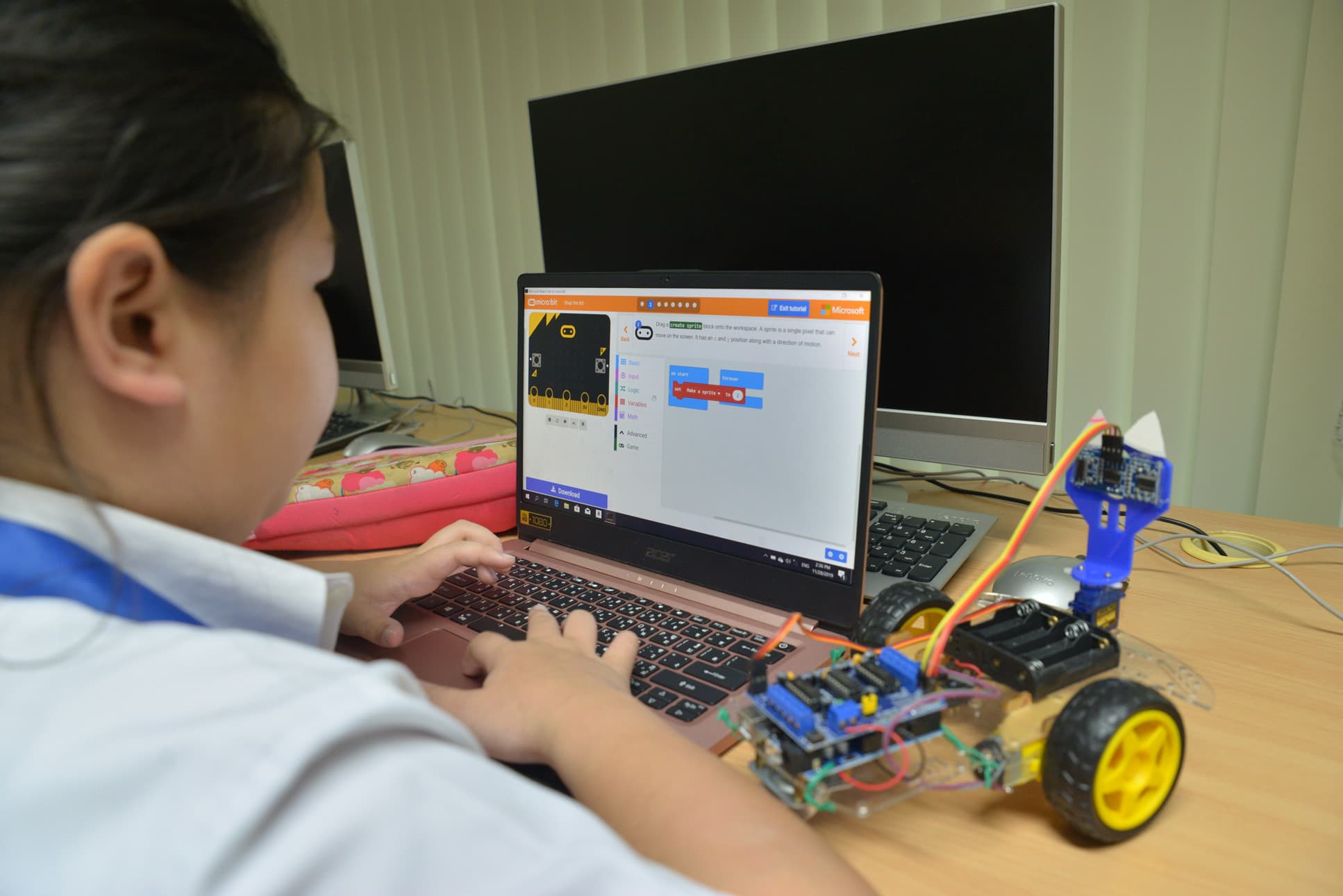 A NIVA middle schooler coding a robot she made in class.
