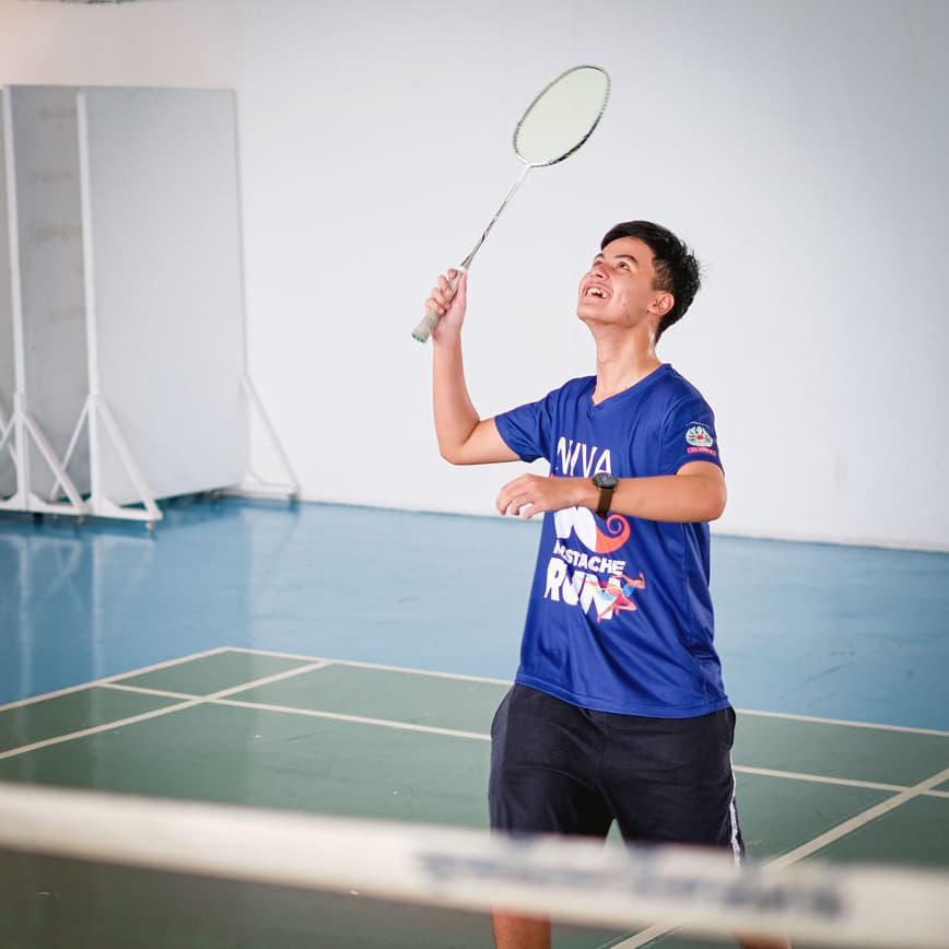 A secondary student playing badminton