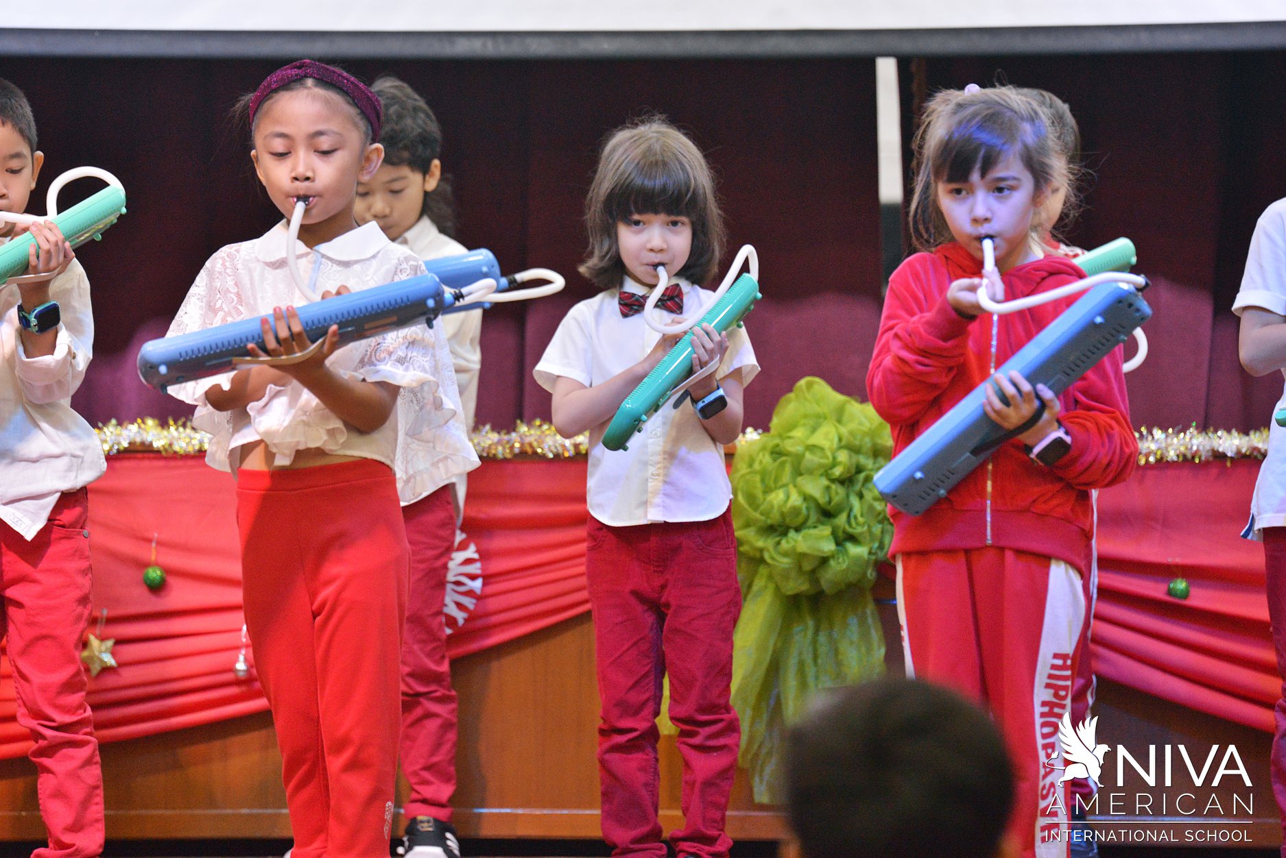 Students performing with melodicas on stage
