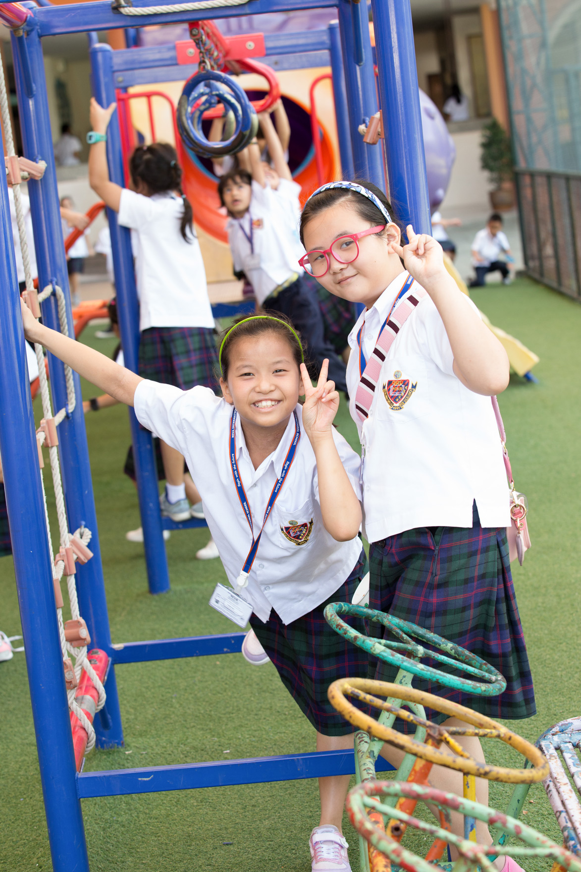 Two children smiling beside the playground equipment