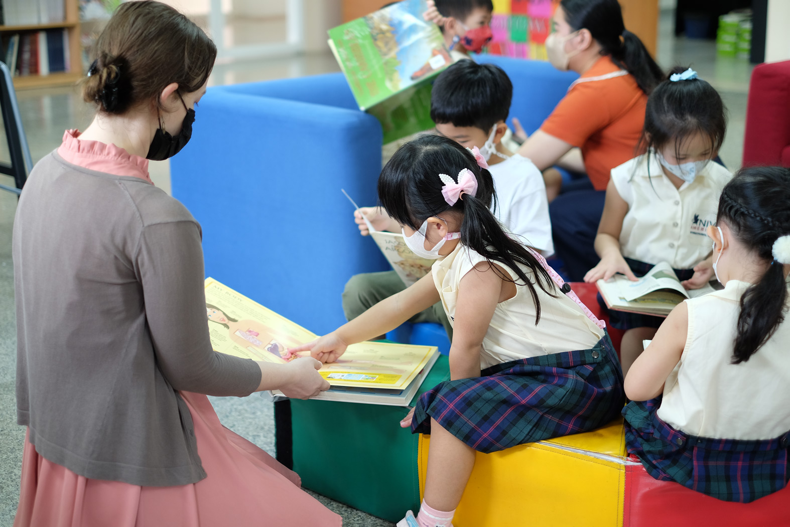 Teacher reading with kindergarten students in the library