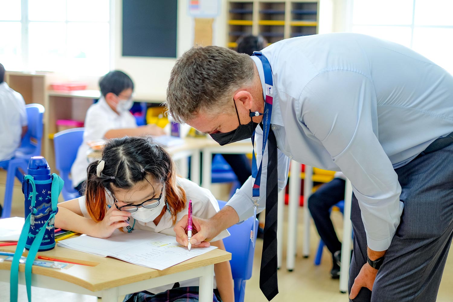 Teacher helping an elementary student with her classwork