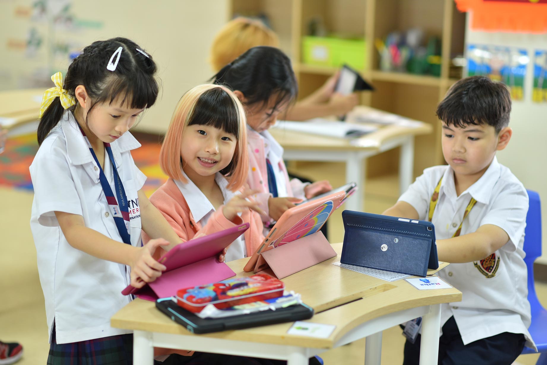 Elementary students sharing a tablet in class