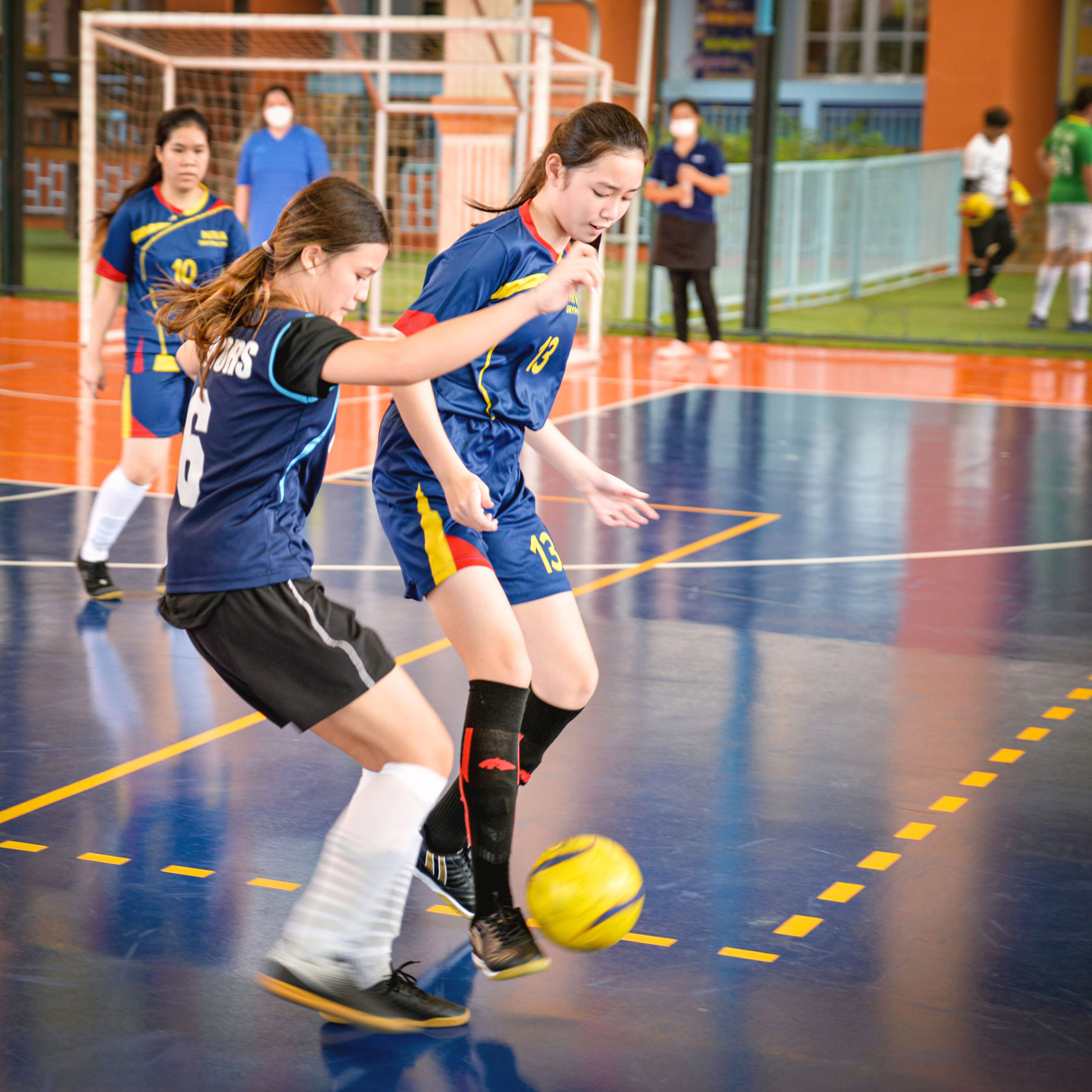 Students competing for the ball in a futsal match