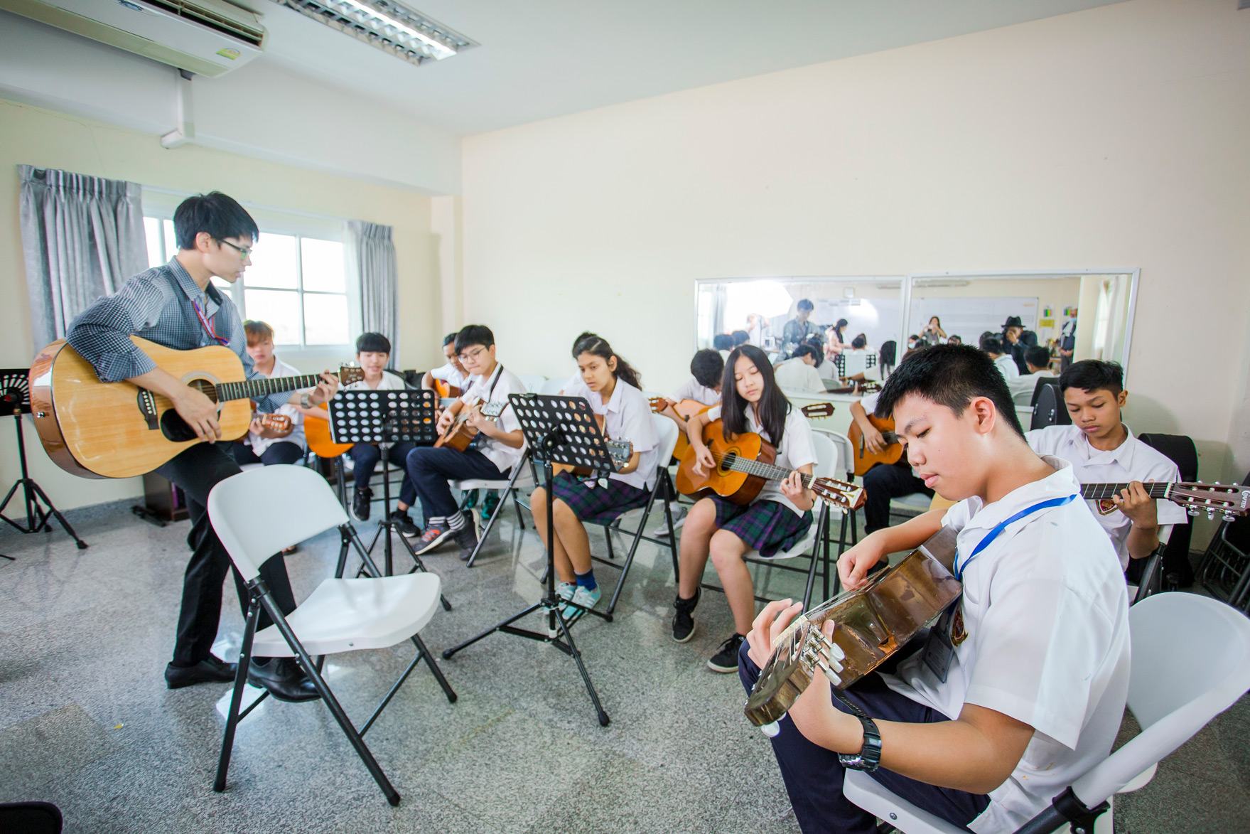 Students practicing guitars in a classroom