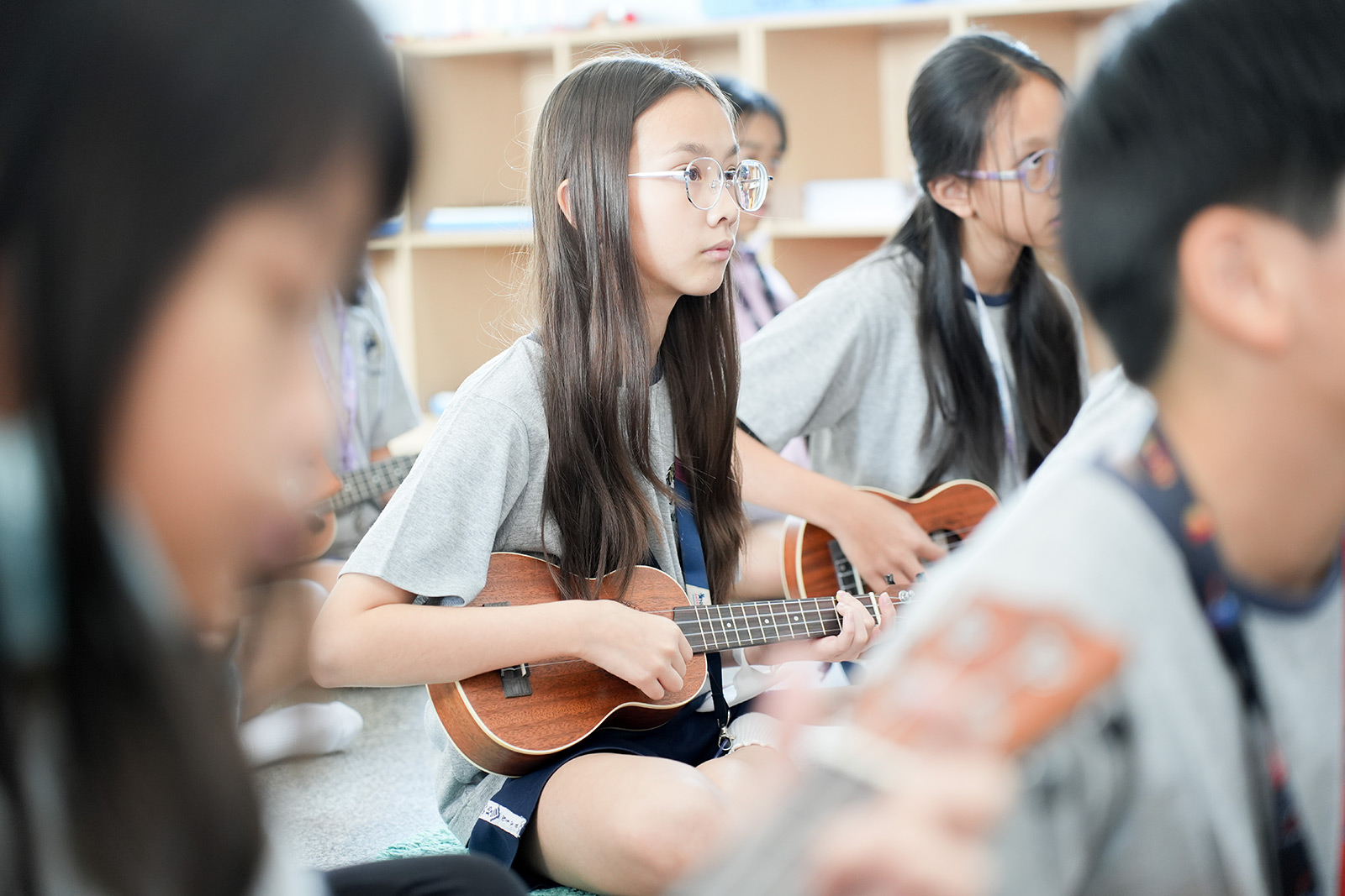 Students learning to play the ukulele in music class