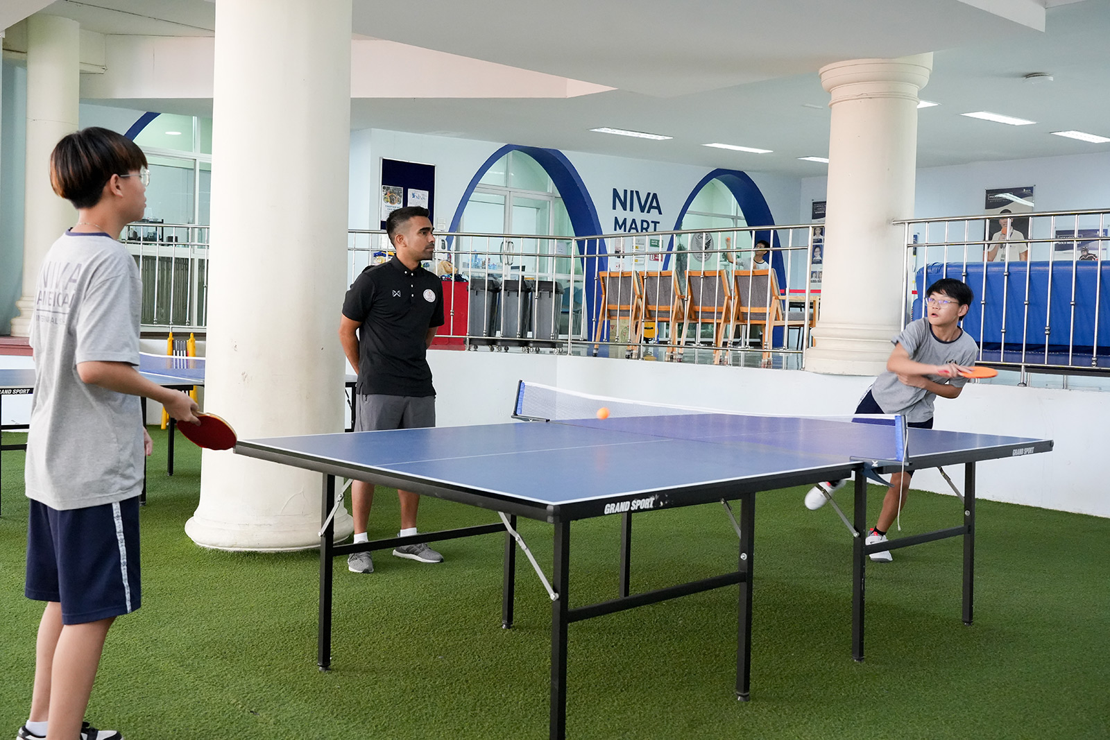 Students playing table tennis in the patio