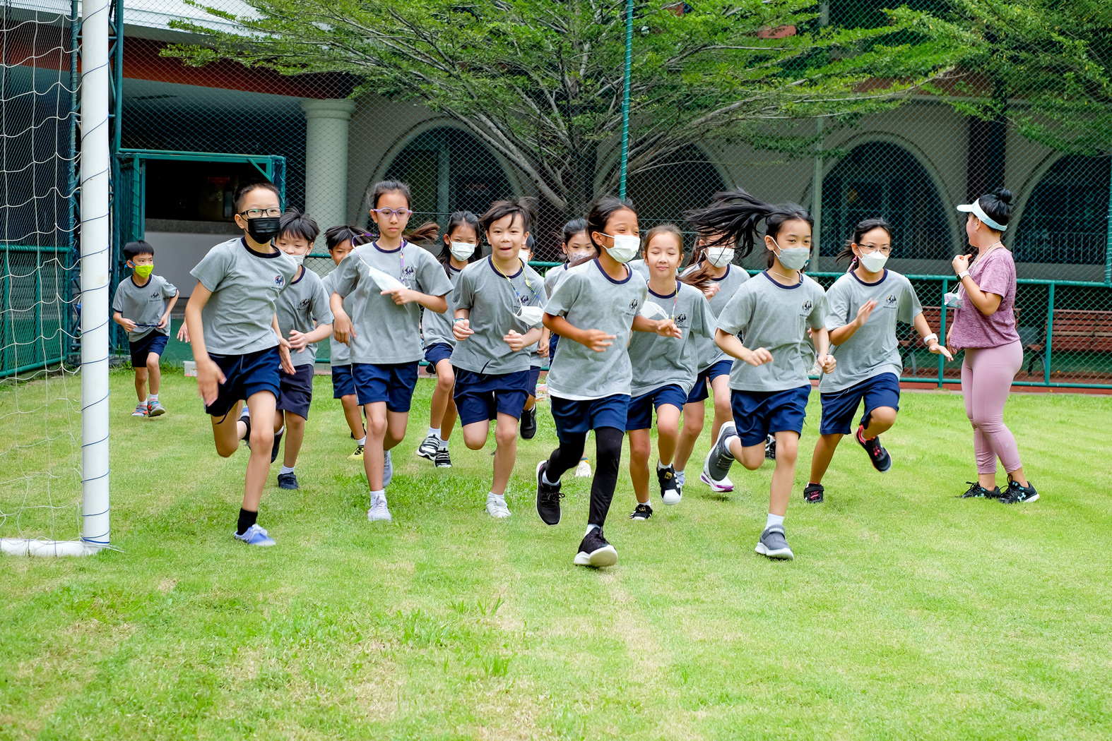 Students running together during PE on the field