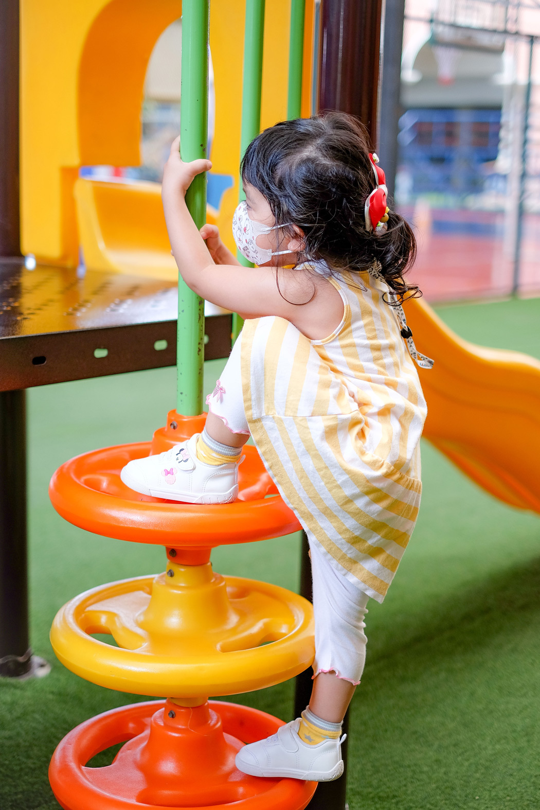 Nursery child climbing colorful playground steps