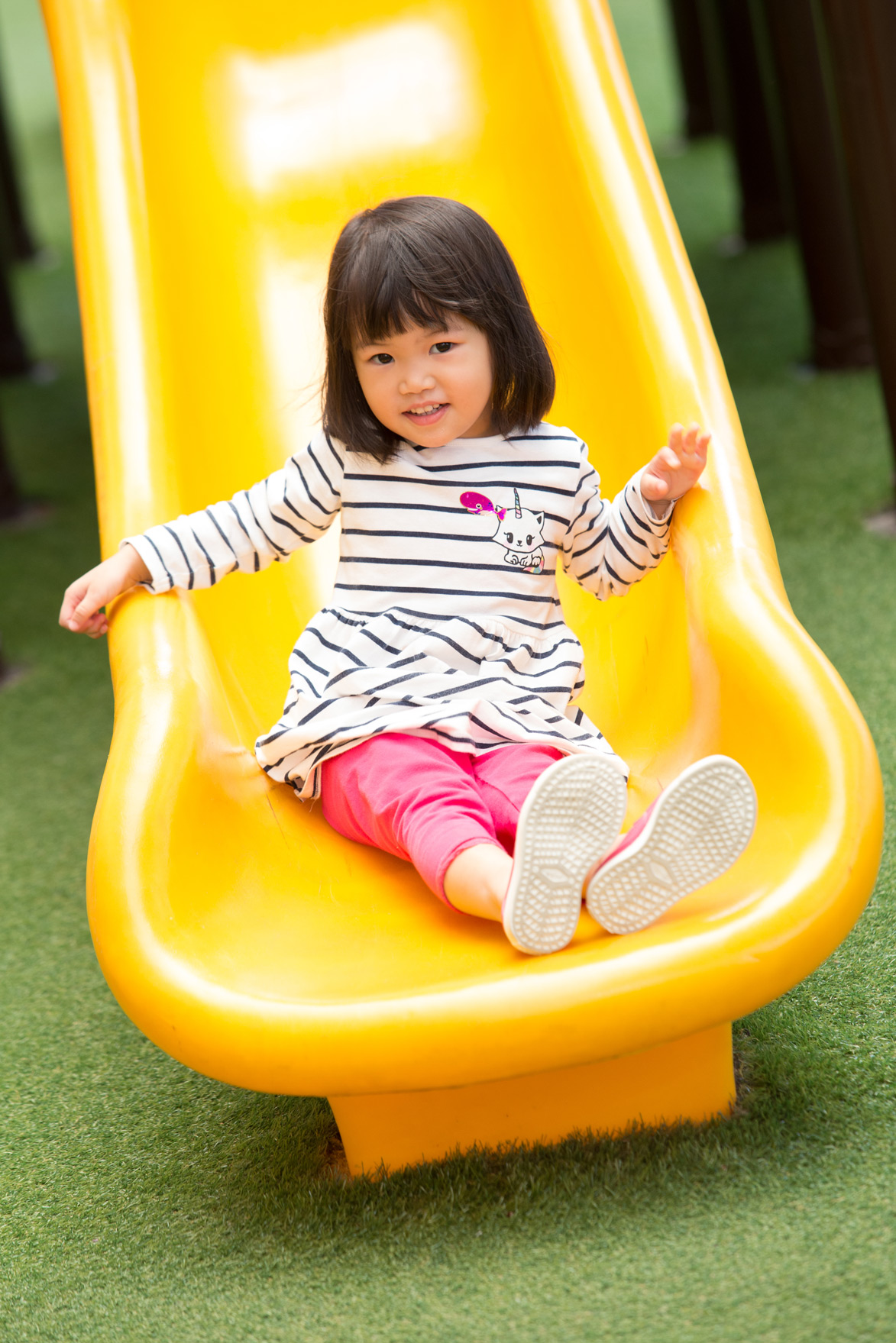 Nursery child sitting on a yellow slide