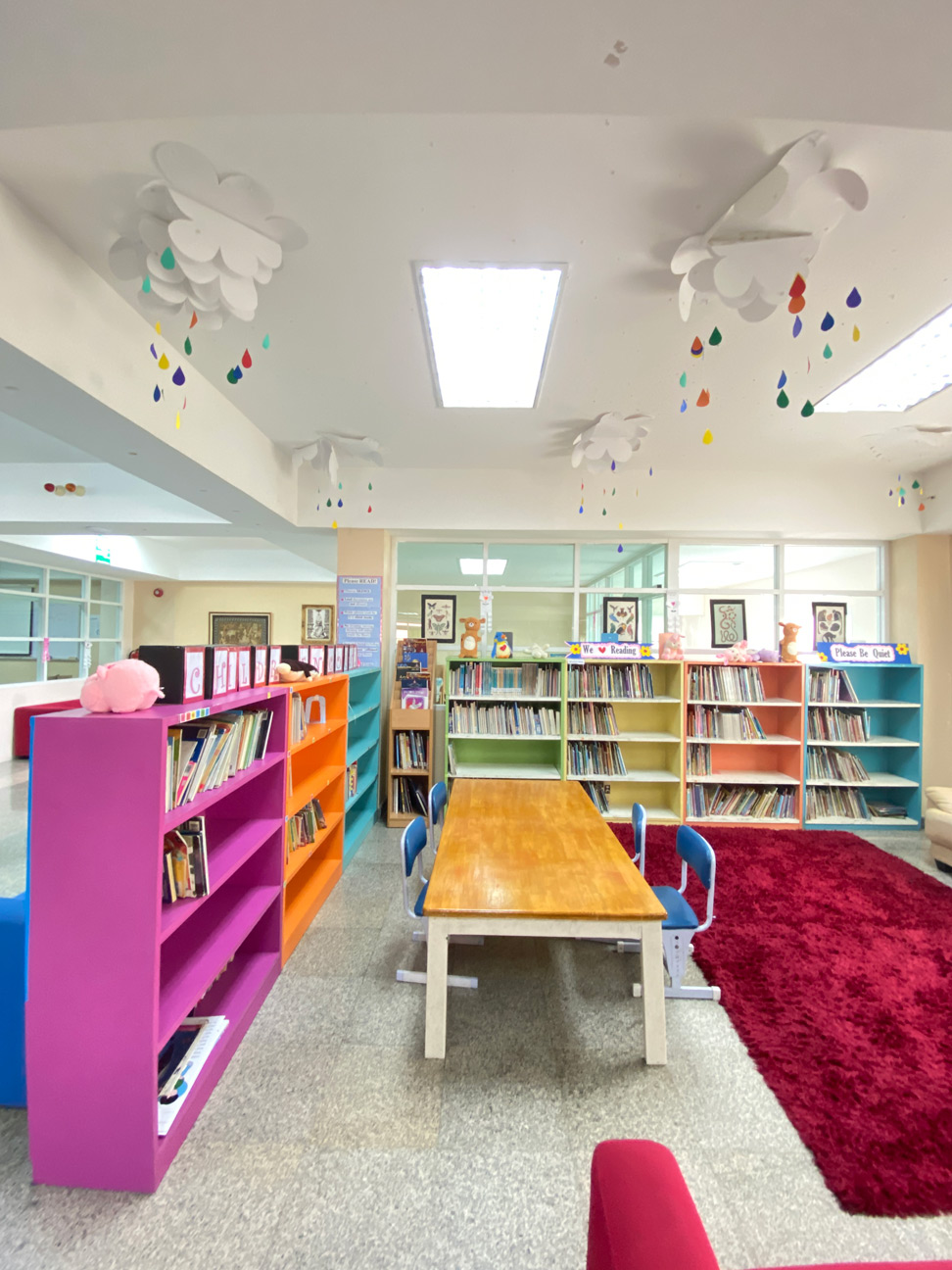 Library area with low shelves and colorful seating for young children